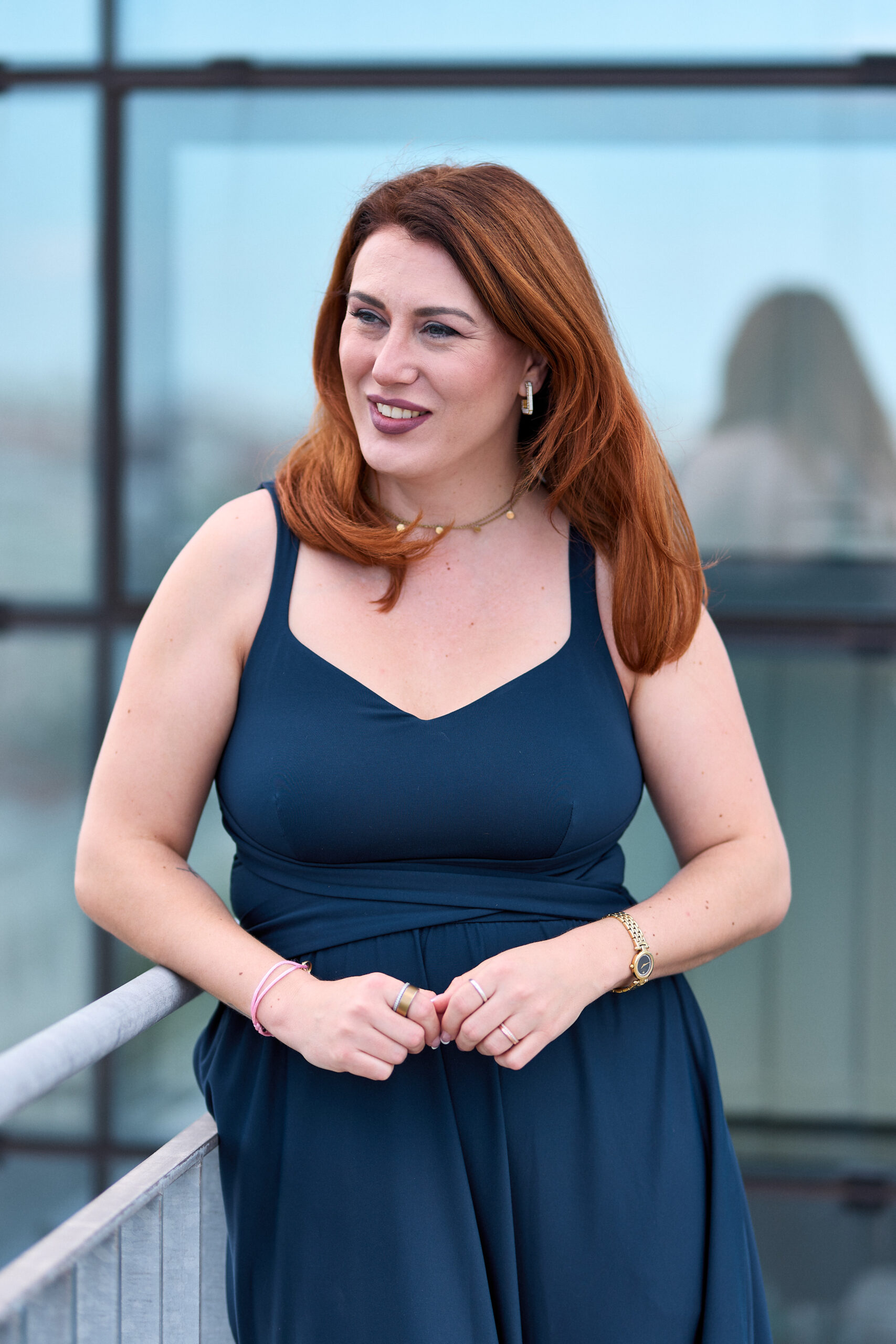 Nadja-Schwarzenau-Autorin-hinter-kleine-Künstler-Malbücher_c_Daniel_Taladrid Frau in langem dunkelblauen Kleid auf vor einer Glaswand.