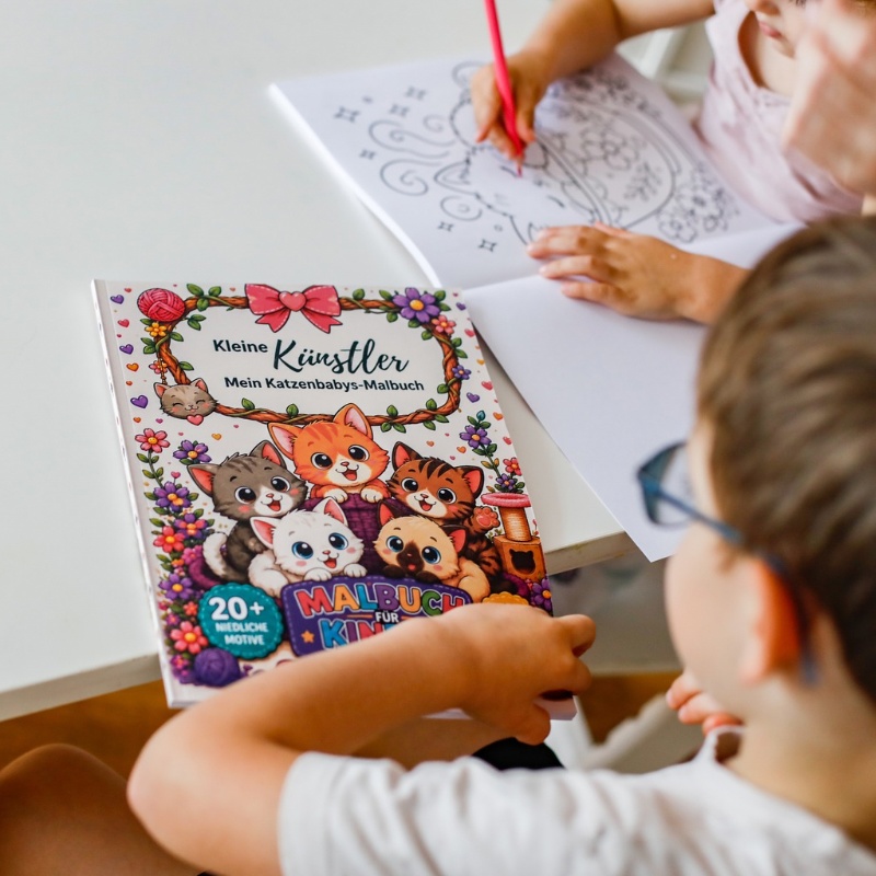 Kind malt im Katzenbabys-Malbuch Kind malt eine Katzenfigur im Kleine Künstler Katzenbaby-Malbuch für Kinder ab 4 Jahren aus